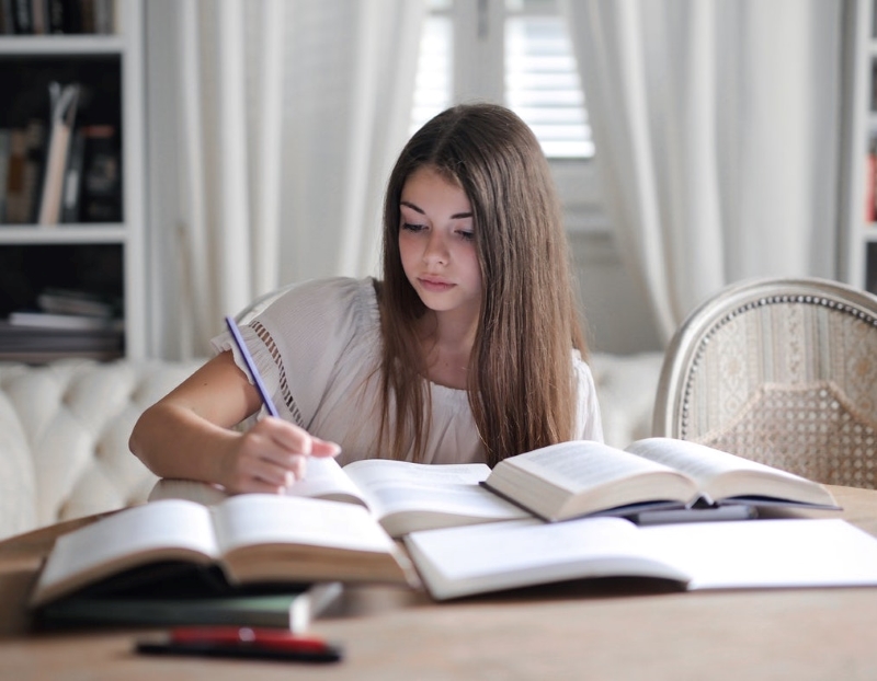 teenage girl studying and writing